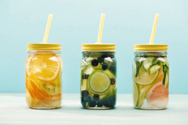 mavi üzerinde izole Pipetler ile meyveler, meyveler ve sebzeler ile organik Detox İçecekler 