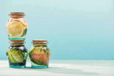 detox drinks in jars with fresh fruits isolated on blue clipart