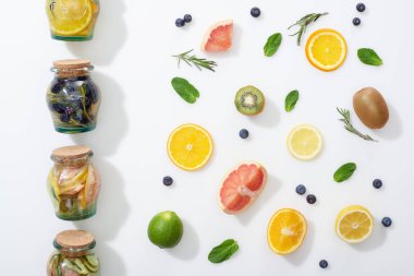 meyve dilimleri, çilek ve otlar yakın kavanozlarda Detox İçecekler üst görünümü