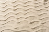 pohled na texturované pozadí s pískem a hladkými vlnami 