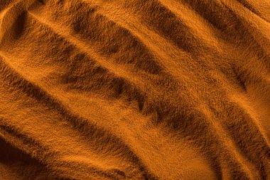 top view of textured sand with smooth waves and orange color filter clipart