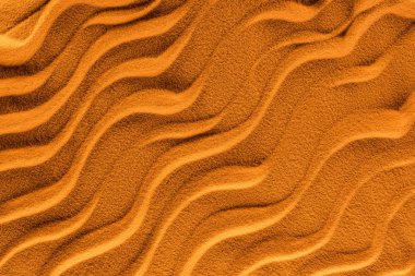 top view of textured sand with smooth waves and orange color filter clipart