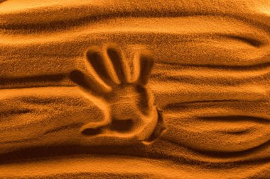 top view of hand mark on sand with color filter and smooth waves clipart
