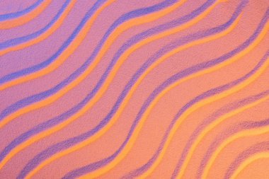 pürüzsüz dalgalar ve neon pembe renk filtresi ile dokulu kum üst görünümü