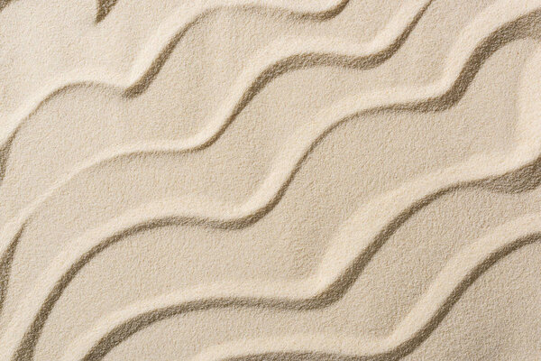 top view of beige sandy background with smooth waves