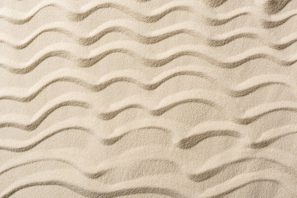 top view of textured background with sand and smooth waves 