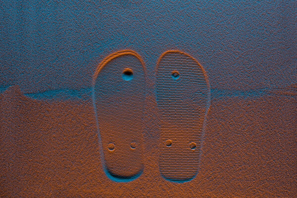 top view of flip flops mark on sand with color filter