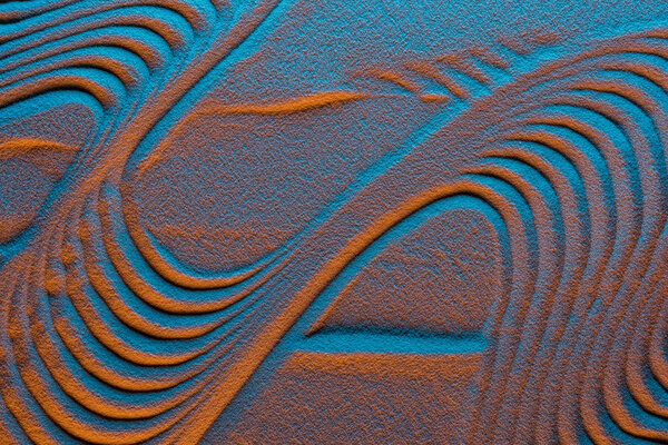 top view of textured sandy background with color filter and abstract waves