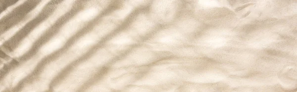panoramic shot of sand with shadows and copy space
