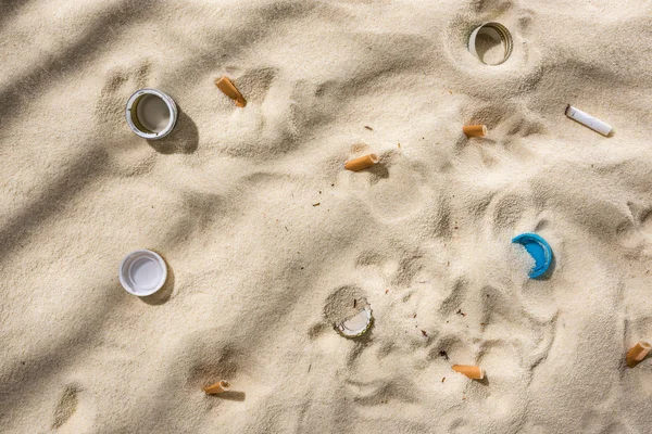 Muscheln Kronkorken Verstreute Zigarettenstummel Plastikflaschenverschlüsse Auf Sand — Stockfoto