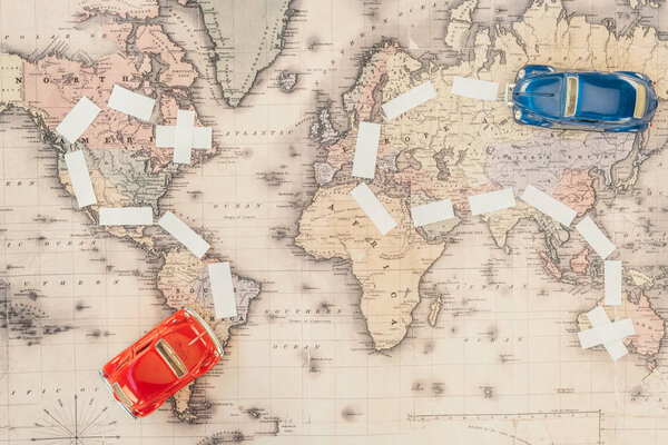 Top view of red and blue toy cars on world map