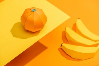 Turuncu karton muz ile sarı kağıt üzerinde origami mandalina Seçici Odak