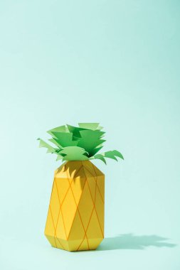 handmade yellow paper pineapple on turquoise with copy space clipart