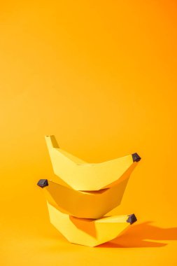 yellow paper bananas on orange with copy space clipart