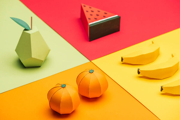 origami watermelon, pear, tangerines and bananas on colorful paper