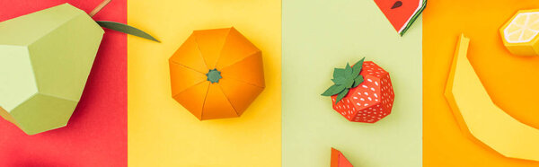panoramic shot of various origami fruits on multicolored paper stripes