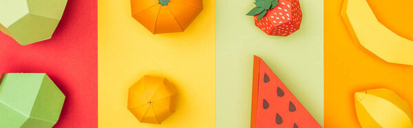 panoramic shot of various handmade origami fruits on colorful paper stripes