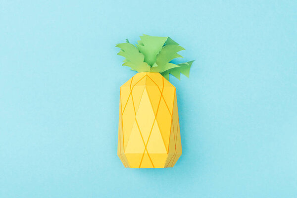 top view of handmade paper pineapple isolated on blue