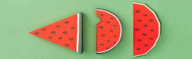 panoramic shot of handmade paper red watermelon slices isolated on green clipart