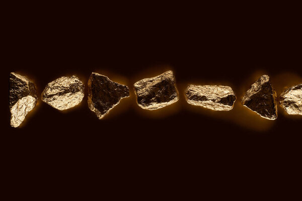 top view of gold shiny stones in row isolated on black