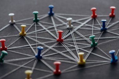 colorful pins connected with strings isolated on grey, network concept