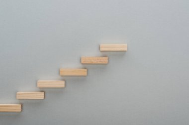 top view of wooden blocks symbolizing career ladder isolated on grey with copy space clipart