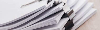 panoramic shot of stacks of blank paper with metal paper clips clipart