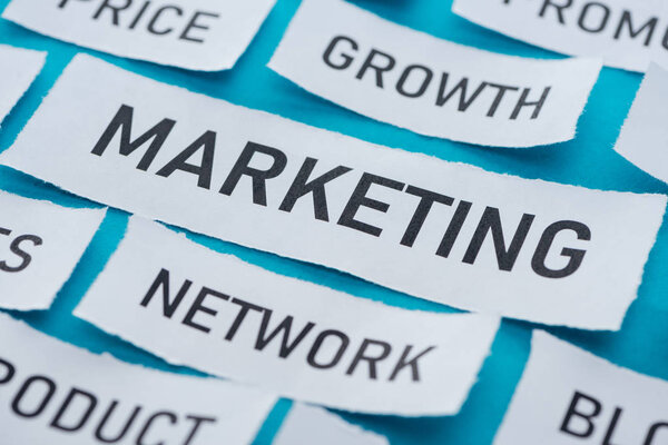 close up view of components of marketing on pieces of paper on blue 