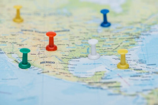 close up view of colorful push pins on world map
