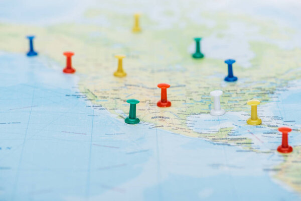 selective focus of colorful push pins on world map with copy space