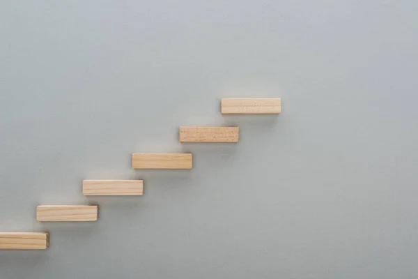 コピースペースで灰色に隔離されたキャリアのはしごを象徴する木製のブロックのトップビュー — ストック写真