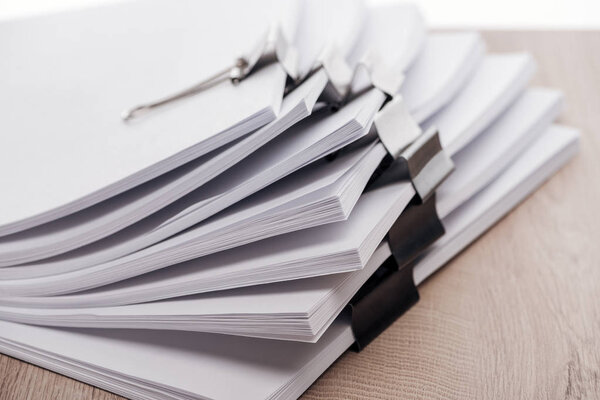 close up view of stacks of blank paper with metal binder clips 