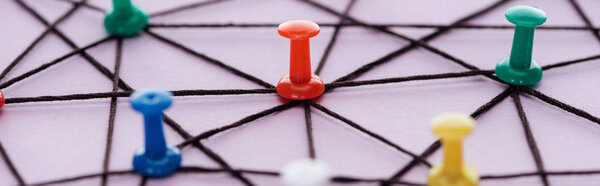 panoramic shot of push pins connected with strings Isolated On pink, network concept