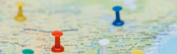 panoramic shot of colorful push pins on world map