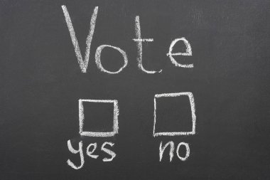 top view of white vote, yes and no lettering on black chalkboard clipart