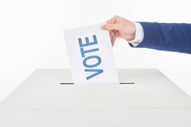 partial view of man putting card with vote lettering in box isolated on white clipart