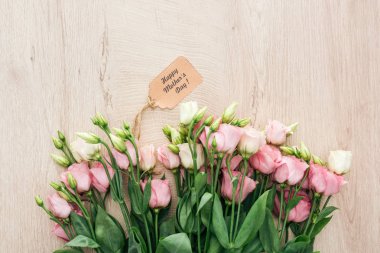 ahşap yüzey üzerinde mutlu anneler günü kağıt etiket ile eustoma çiçek üst görünümü