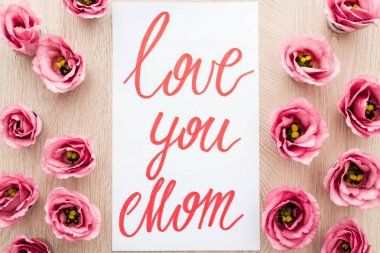 eustoma çiçek ve kart sevgi ile üst görünümü masada anne kelimeleri