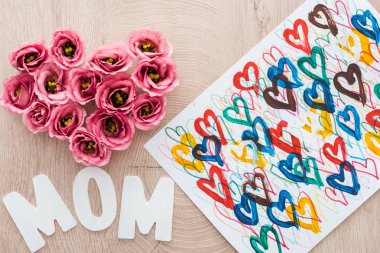 eustoma çiçek, çizim ve ahşap masa üzerinde anne işareti yapılmış kalp işareti üst görünümü