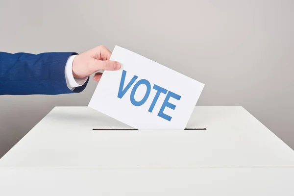 Visão Parcial Homem Colocando Cartão Com Voto Caixa Fundo Cinza — Fotografia de Stock