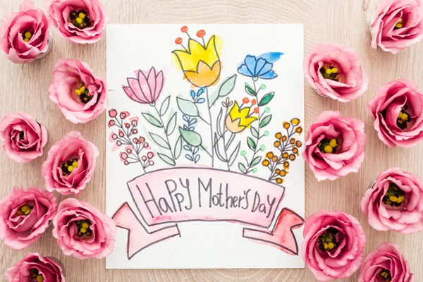 top view of eustoma flowers and card with happy mothers day writing on table
