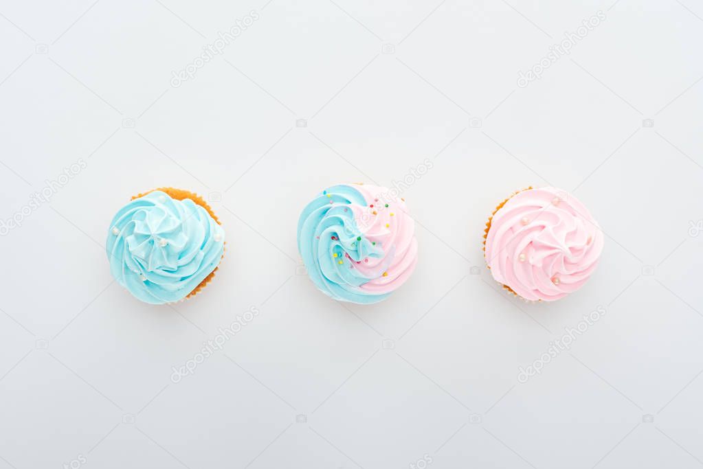 top view of delicious colorful cupcakes with sprinkles in row Isolated On White