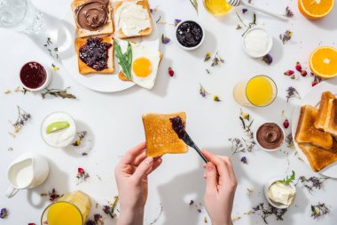 tost tutan ve beyaz içecekler yanında çikolata krem yayılan kadın kırpılmış görünümü 