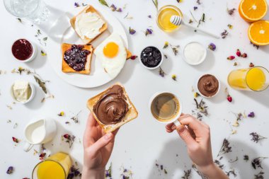 beyaz kahvaltı yakınında çikolata krema ve espresso fincan ile tost tutan kadın kırpılmış görünümü 