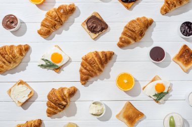 beyaz arkadaş yumurta üzerinde arugula yaprakları ile tatlı kruvasan ve lezzetli tost üst görünümü 