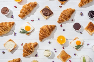 beyaz kurutulmuş çiçekler yakın arkadaş yumurta üzerinde arugula yaprakları ile tatlı kruvasan ve lezzetli tost üst görünümü 