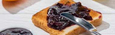 panoramic shot of toast with jam near knife on white  clipart