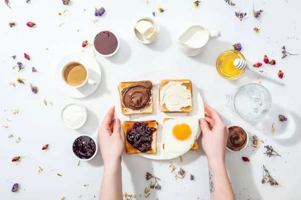 裁剪视图的妇女与纹身在手拿着板与美味的早餐在白色 — 图库照片