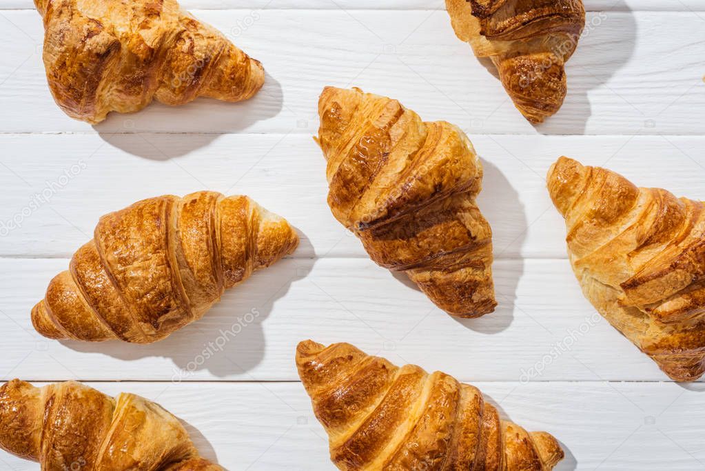 top view of delicious and sweet croissants on white surface 