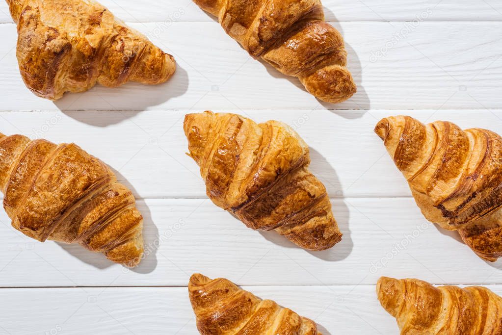 flat lay of delicious and sweet croissants on white surface 